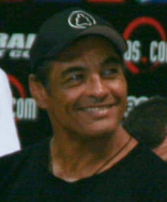 Rickson Gracie photographed at an outdoor event in 2008, wearing a dark cap and black shirt.